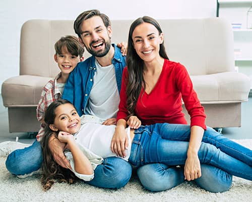 Happy family sitting on floor having fun in their new home in Florida